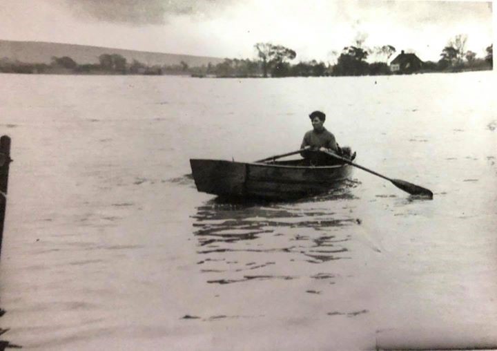 A man in rowing across the floods